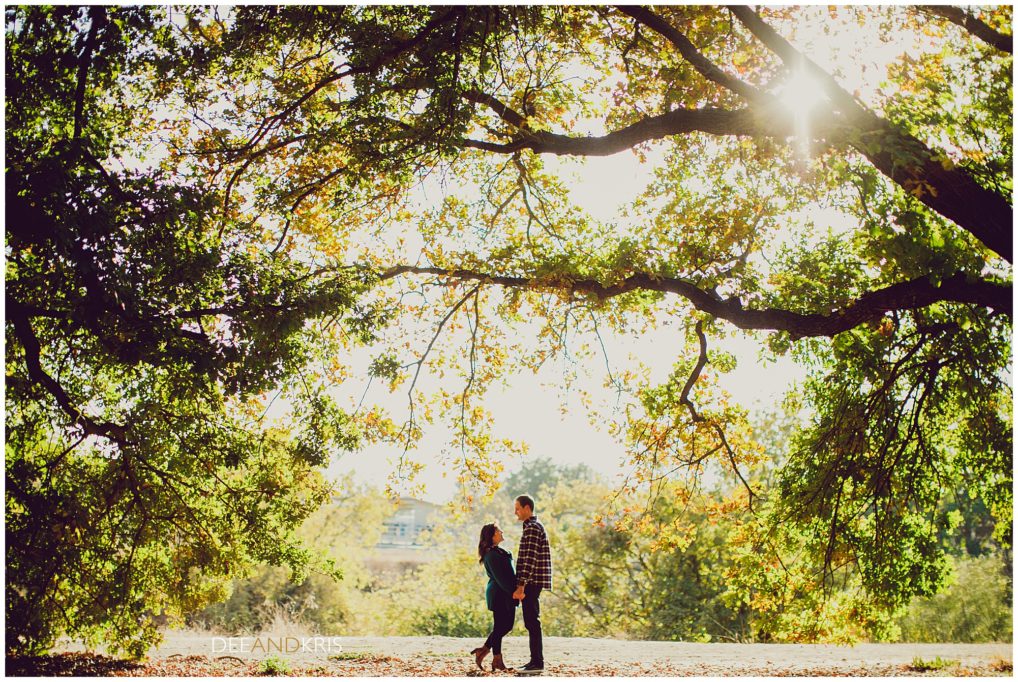 Dee and Kris photography couple at the UC Davis arboretum under large oak tress
