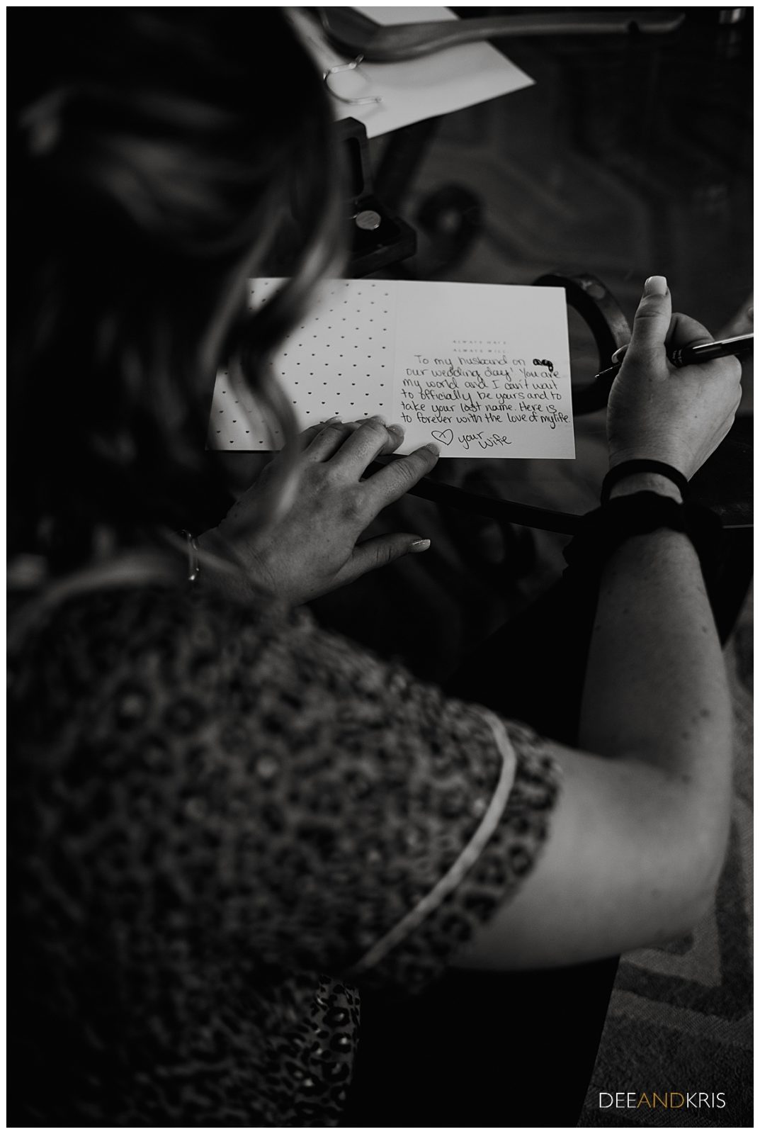 One black and white image of the bride writing out a card for the groom.