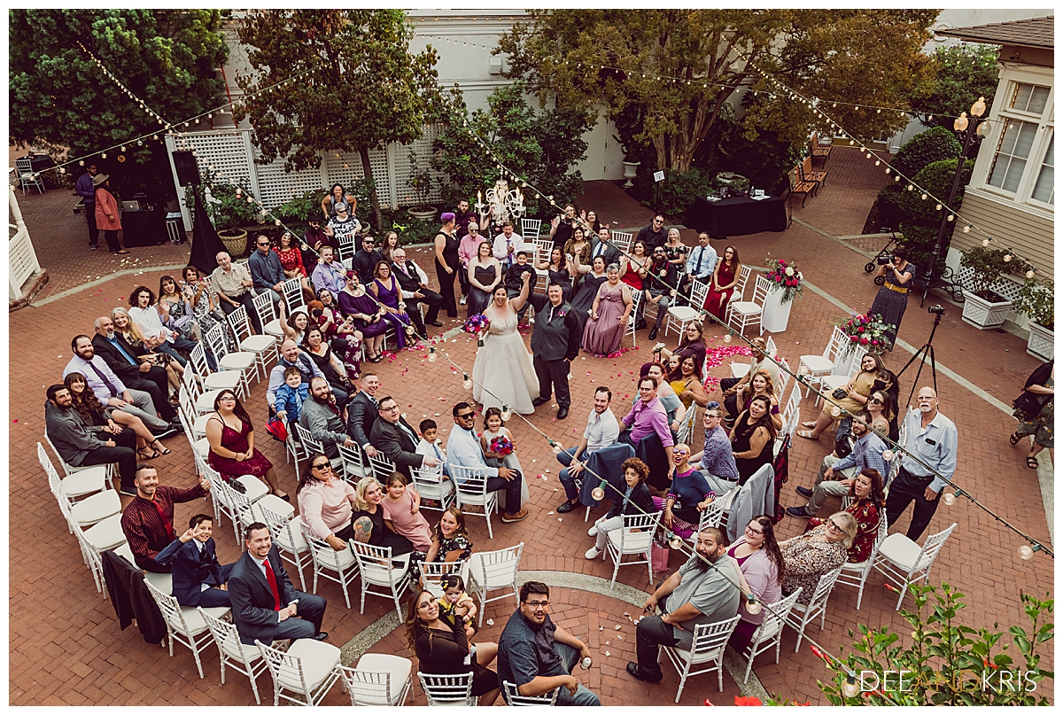 Aerial photo of entire wedding guest party with couple in the center.