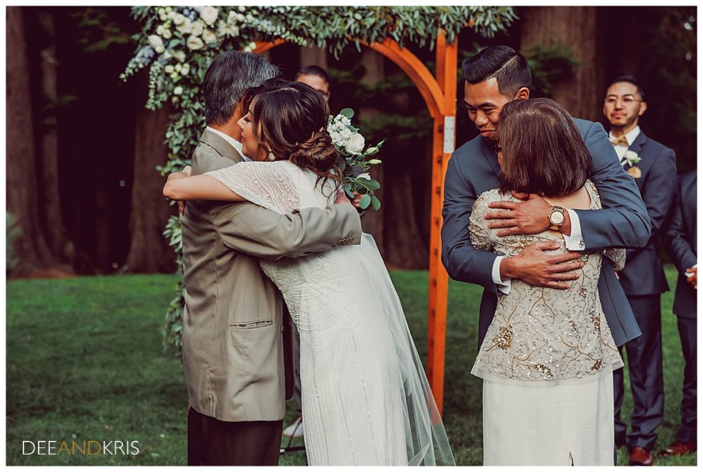 One image of bride hugging her father and groom hugging mother of the bride.