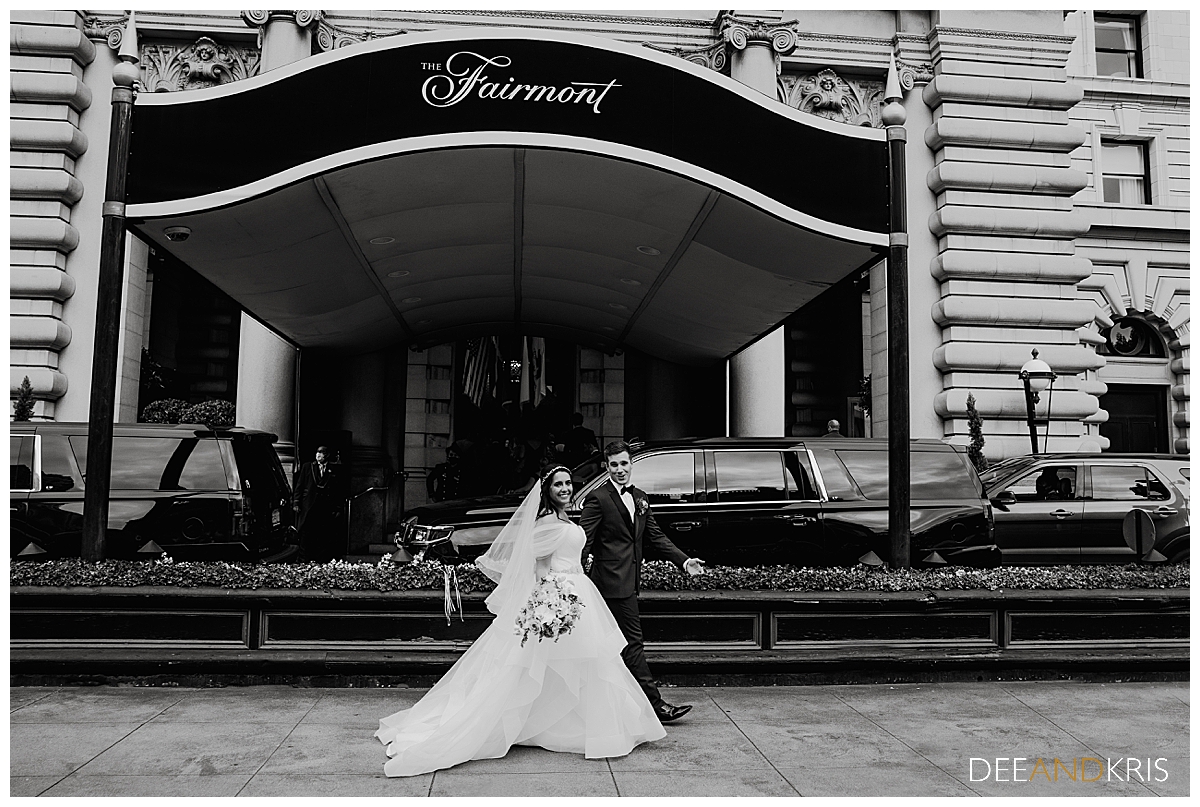 One black and white image of bride and groom walking in front of The Fairmont Hotel doors